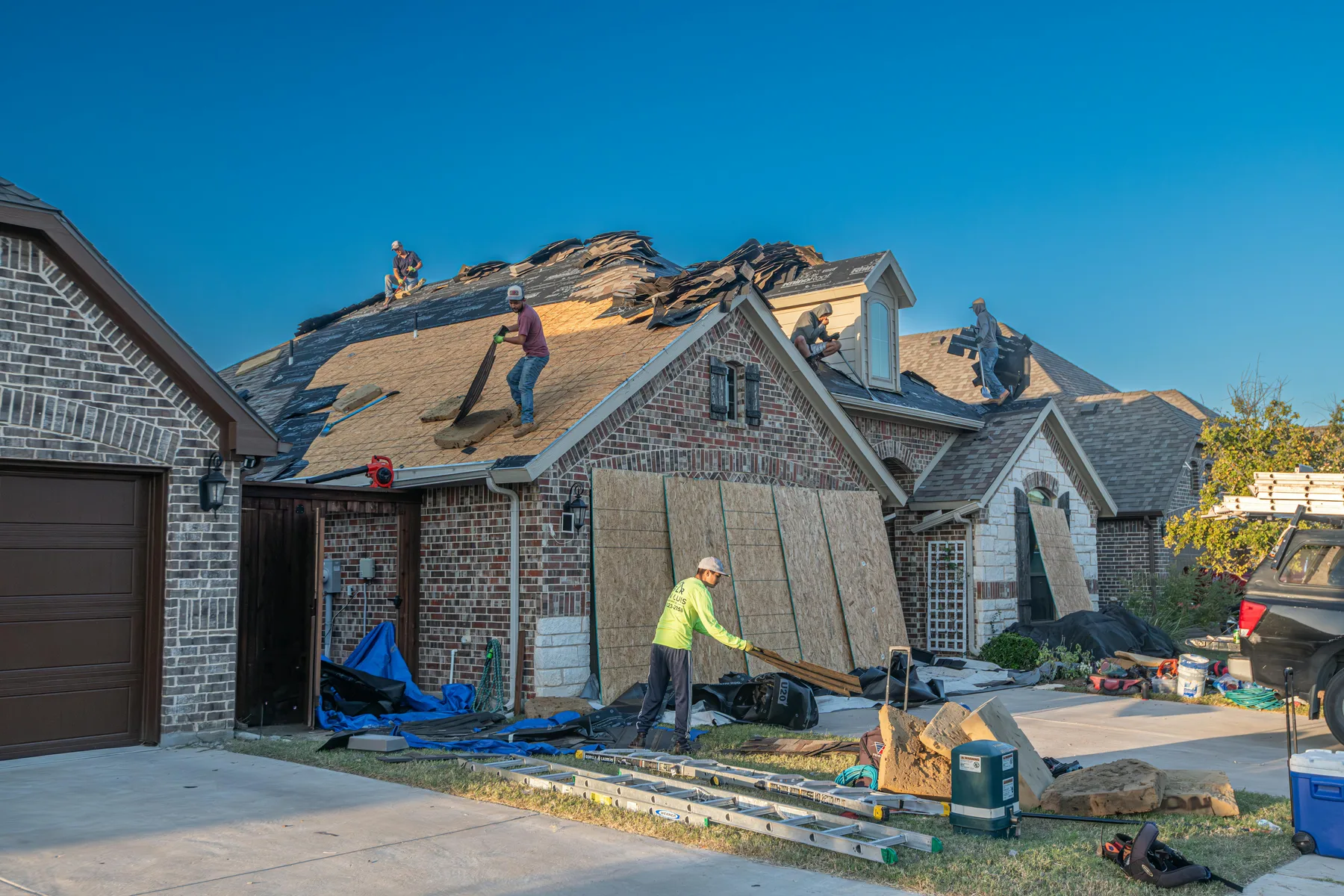 Roofing crew inspecting a residential roof before replacement in the St. Petersburg area